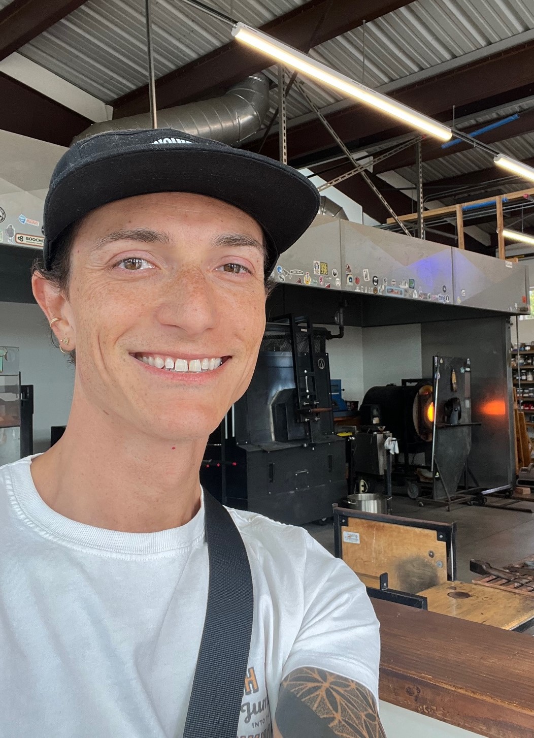 Riley Need in a glassblowing studio, looking at the camera